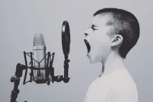 boy yellowing into a microphone